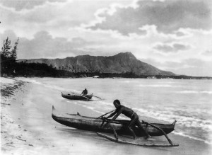 Two_natives_with_outrigger_canoes_at_shoreline,_Honolulu,_Hawaii